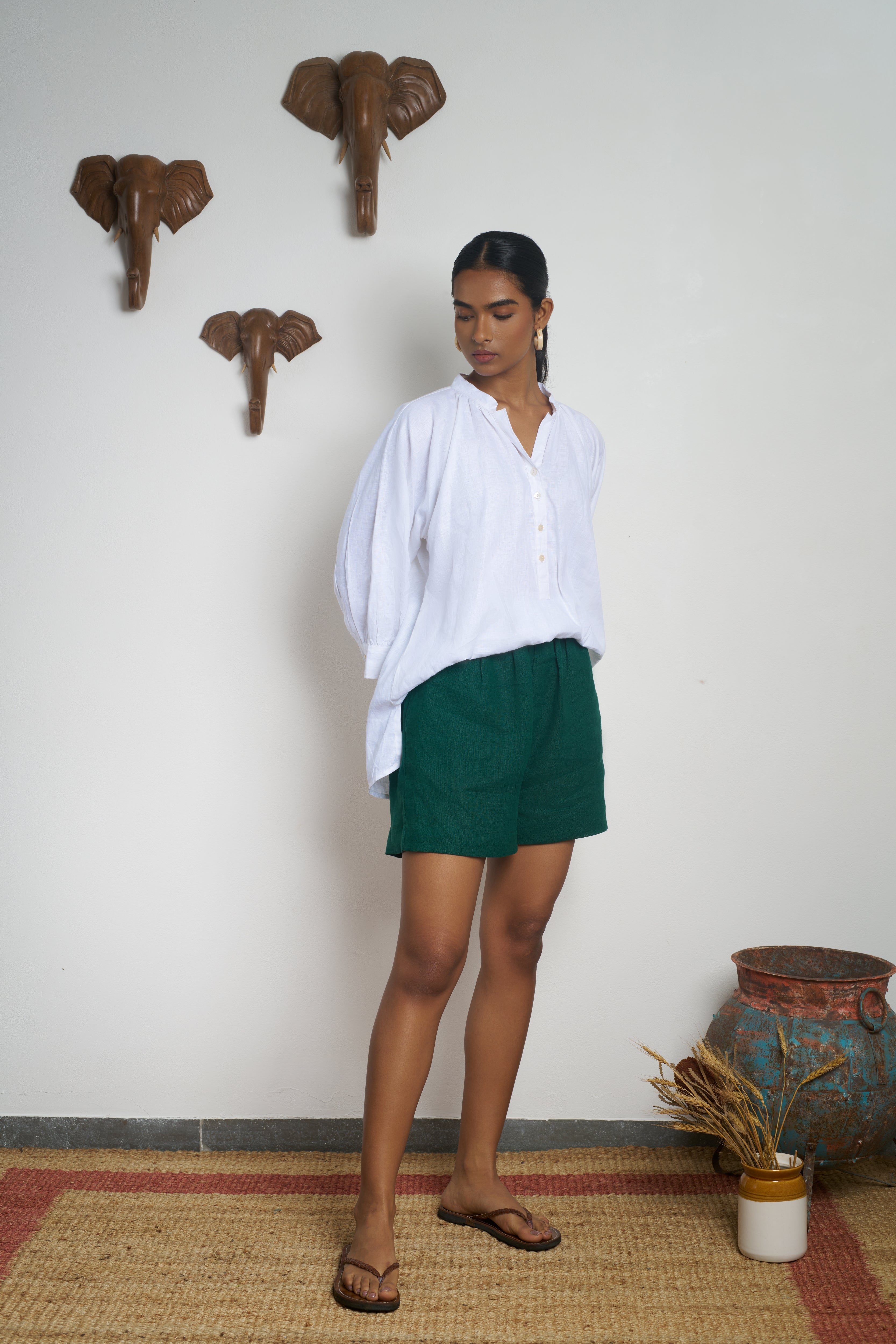 Woman wearing a white shirt and green shorts. everyday sustainable fashion India,  timeless women’s fashion
