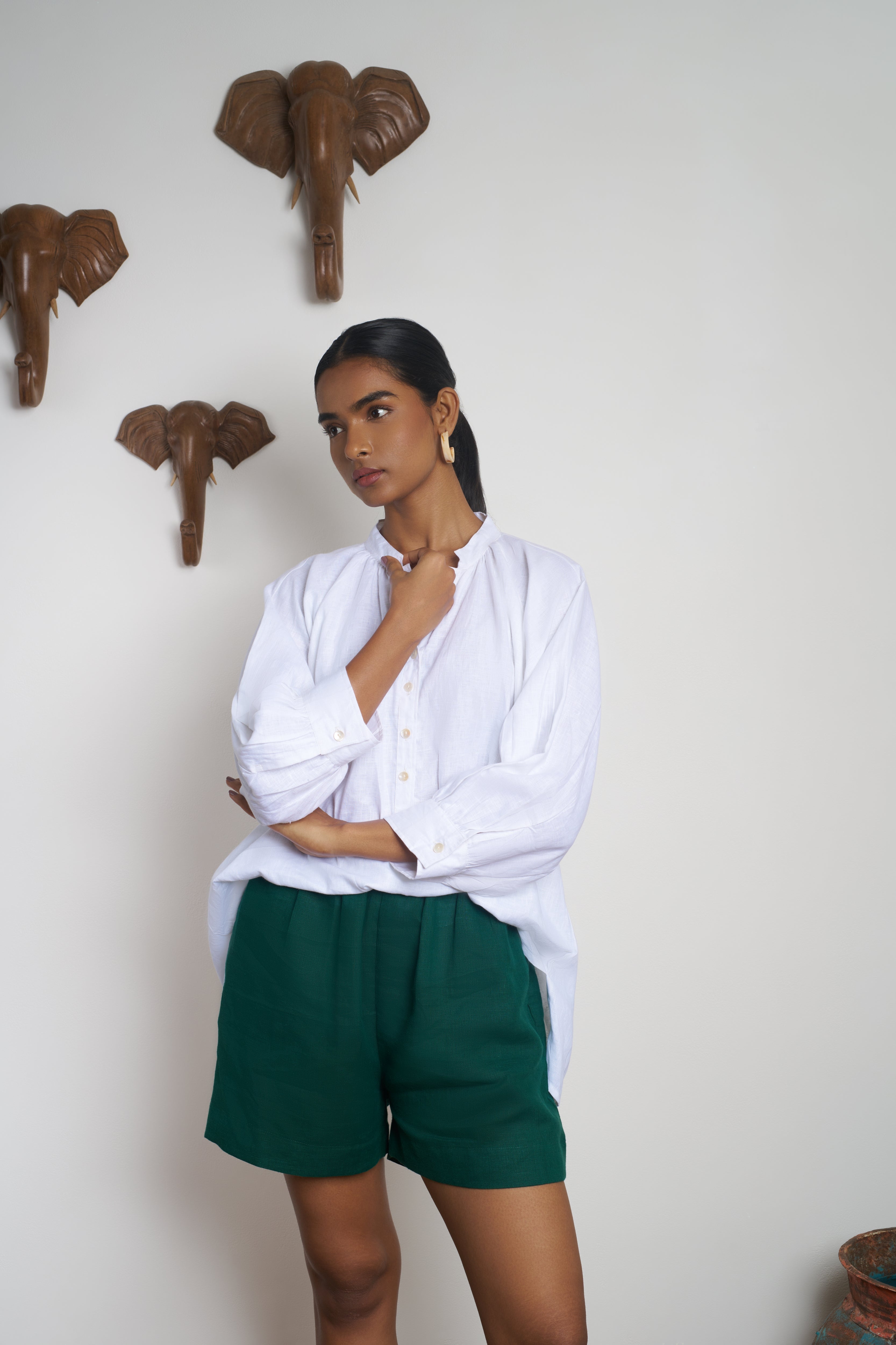 Woman wearing a white shirt and green shorts.  everyday sustainable fashion India, timeless women’s fashion