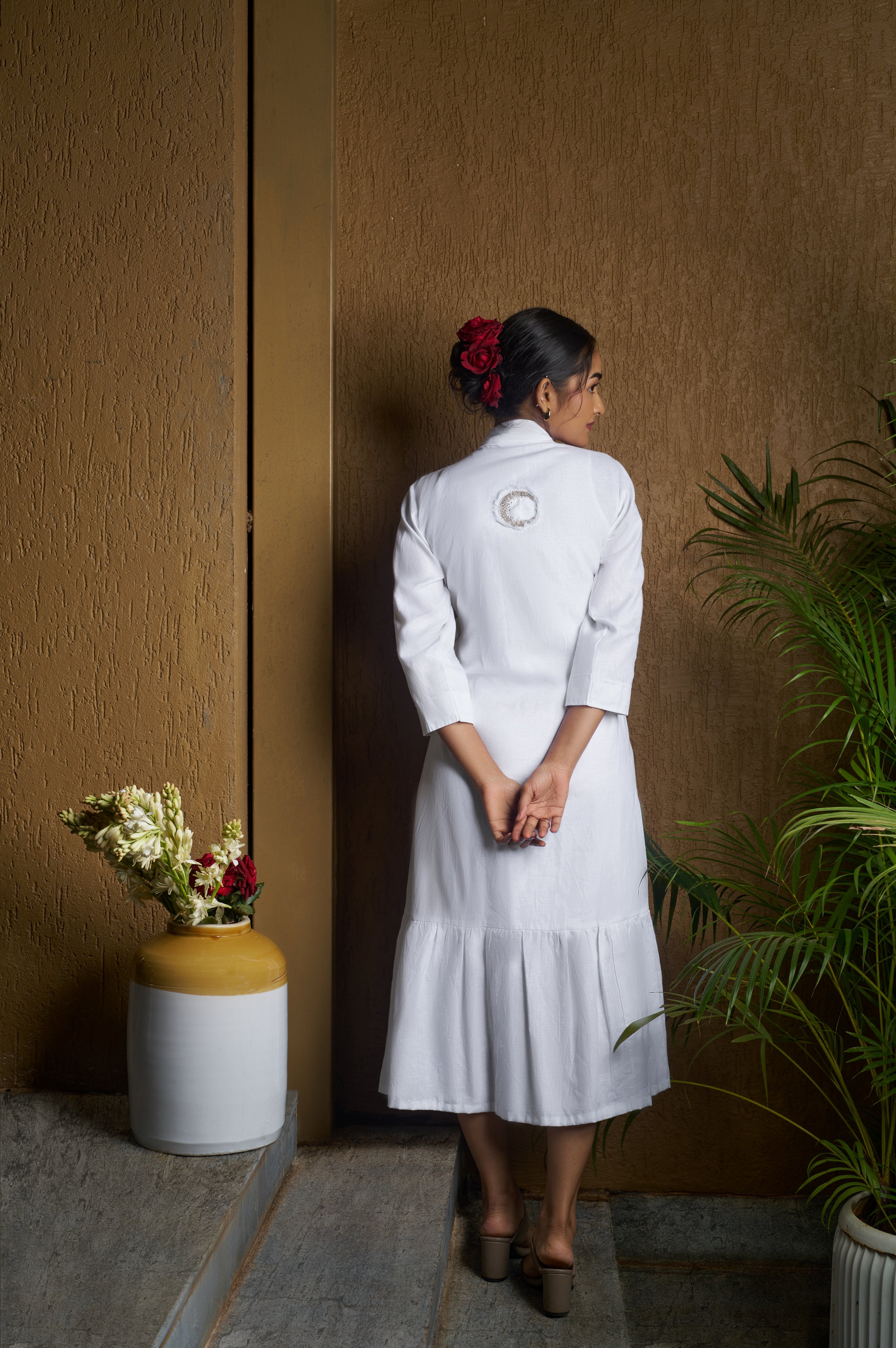 Woman wearing a white dress with a moon embroidery.  Casual linen fashion, comfortable linen dresses India