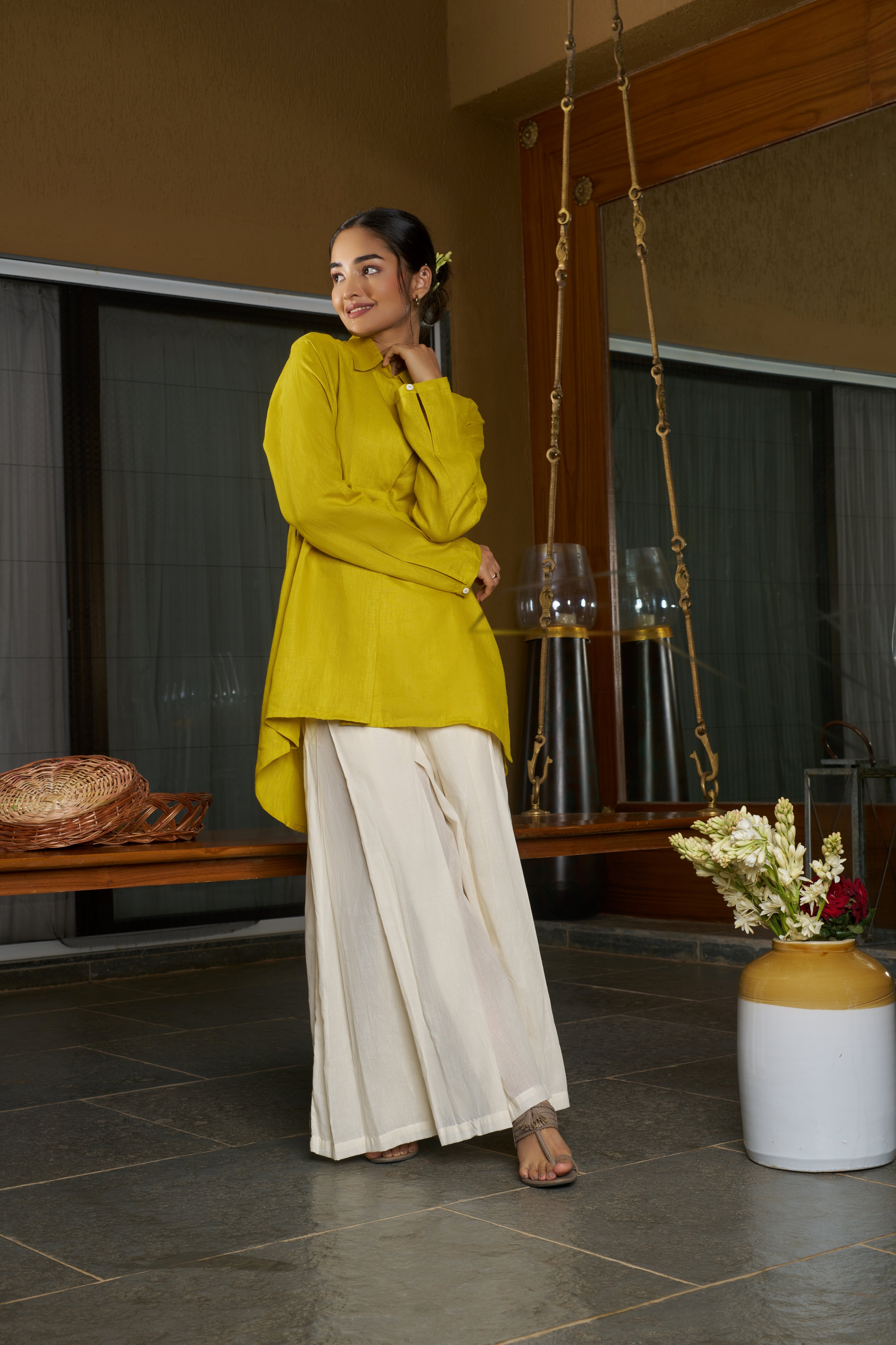 Woman in a yellow top and white skirt standing in a room. everyday sustainable fashion India, 
linen co-ord sets India everyday sustainable fashion India, 
linen co-ord sets India