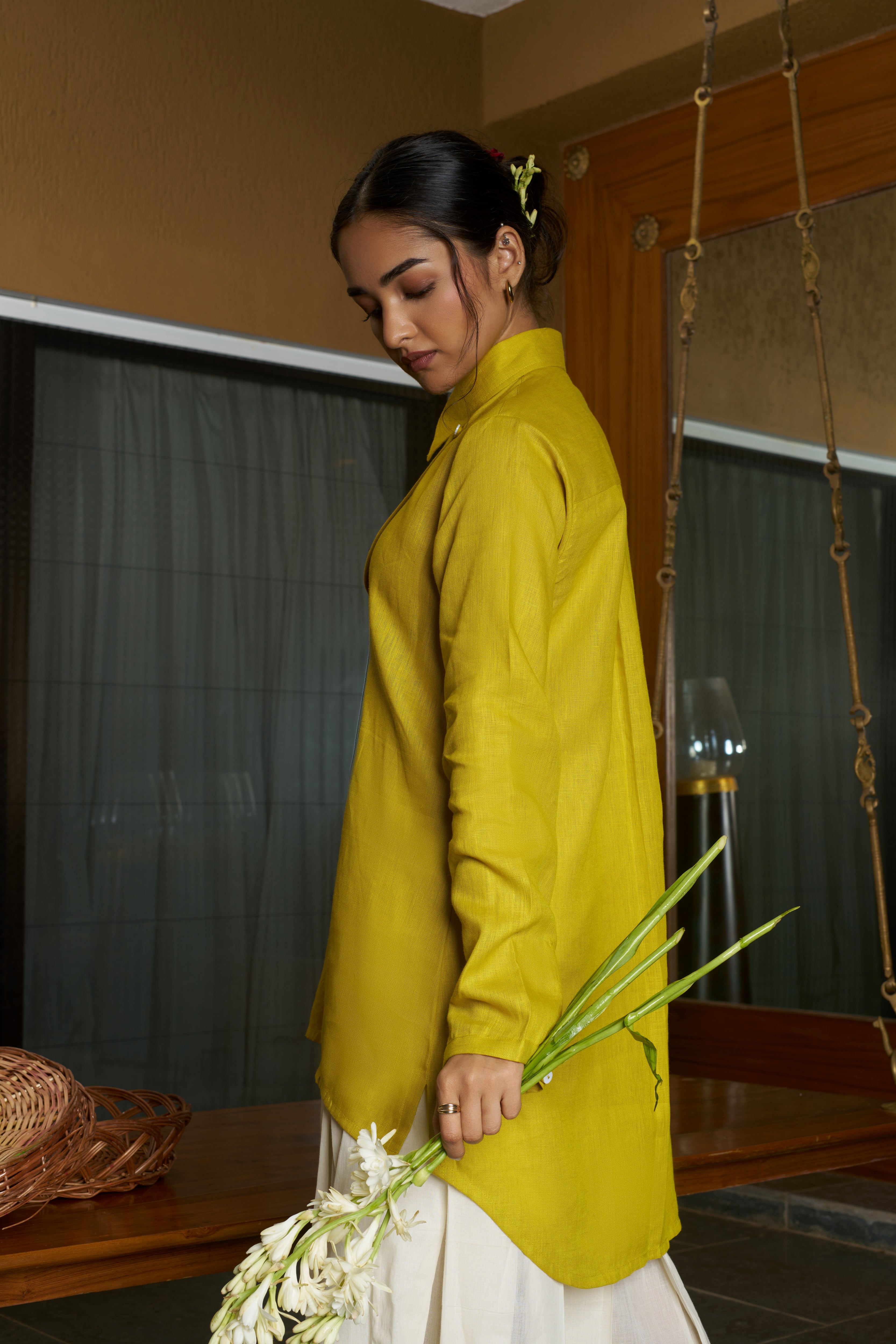 Woman in a yellow outfit holding flowers indoors everyday sustainable fashion India, linen co-ord sets India