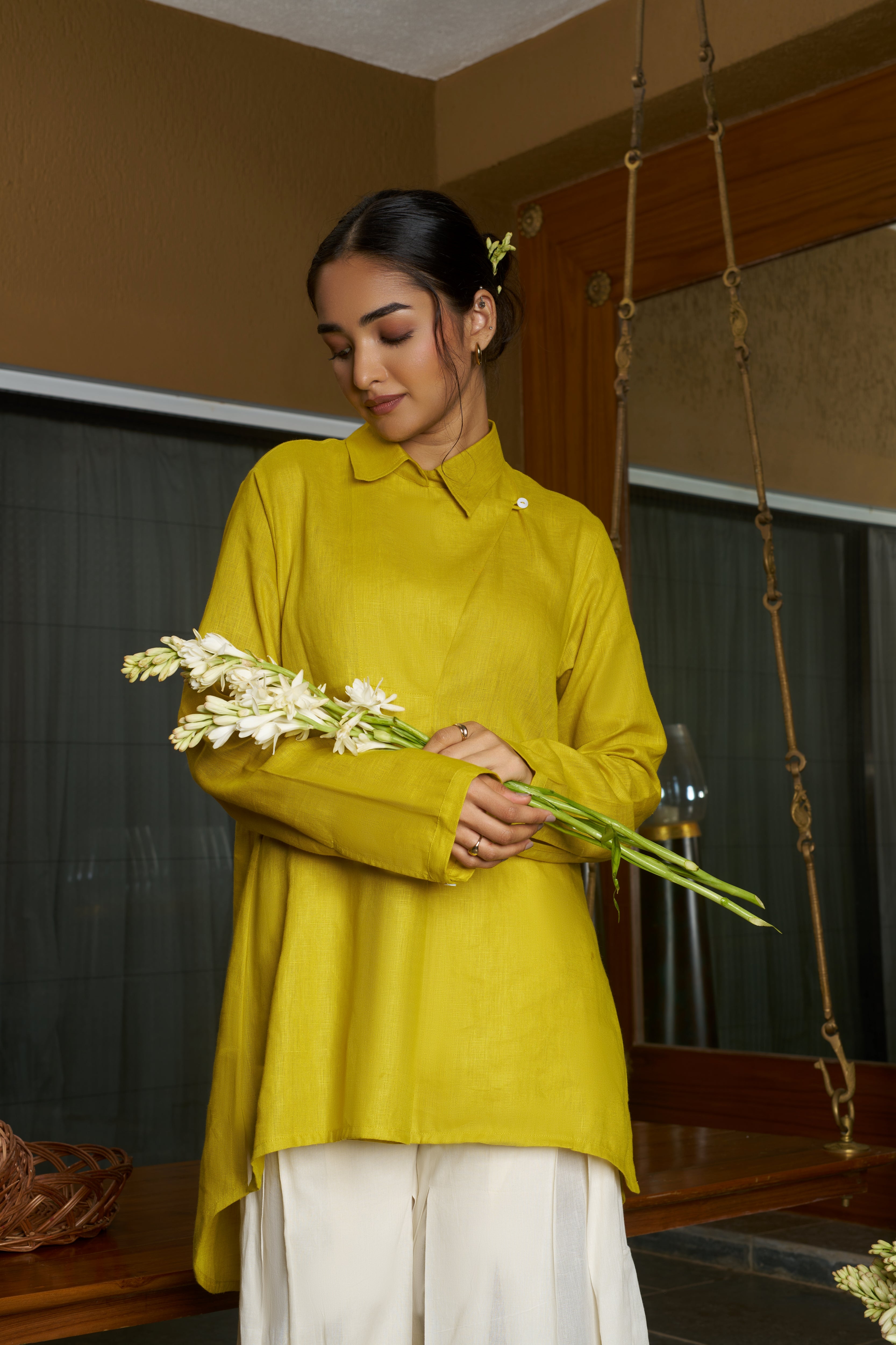 Woman in a yellow top holding flowers.everyday sustainable fashion India, linen co-ord sets India