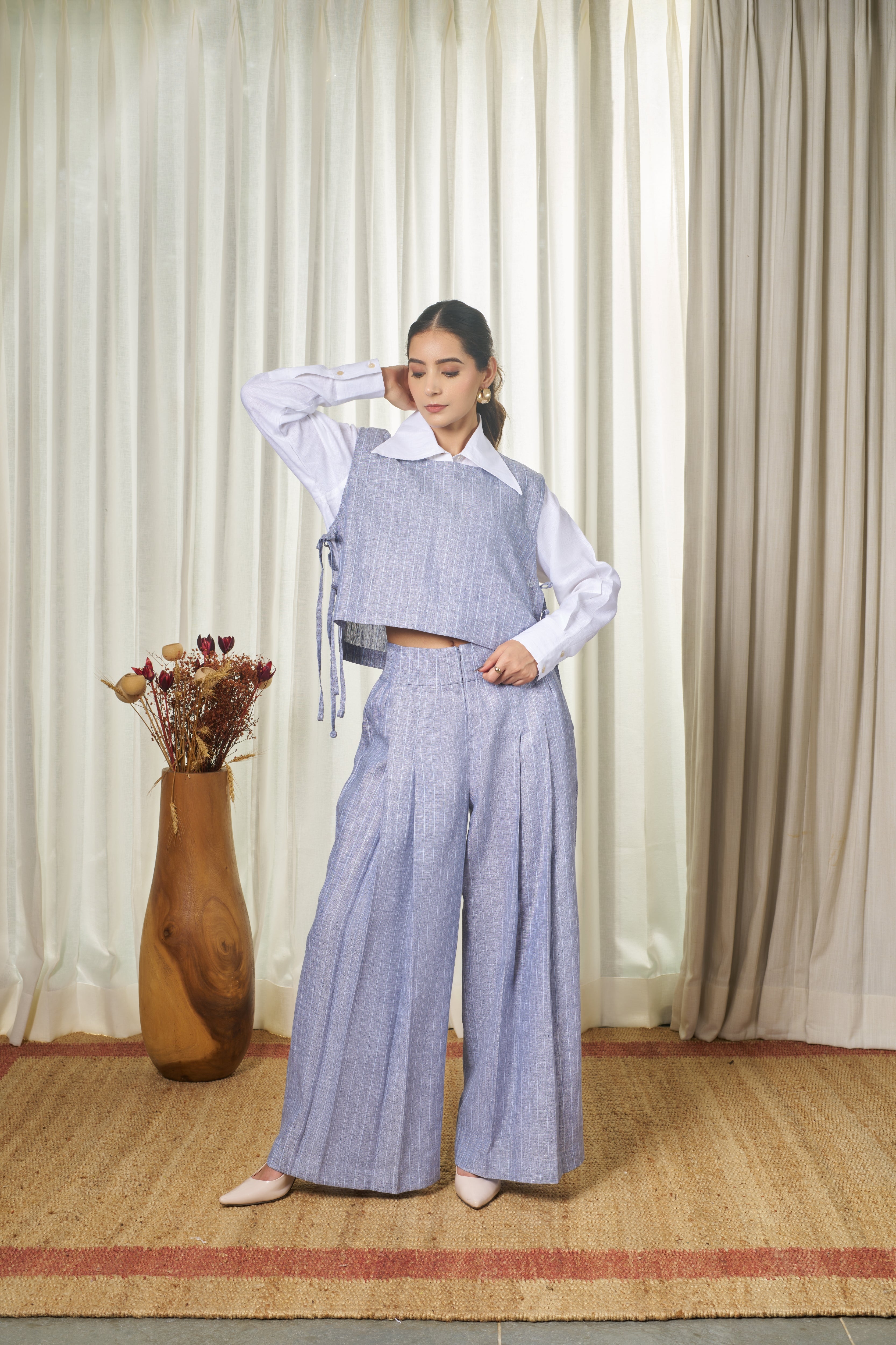 Woman wearing a blue striped outfit with a white shirt.  handmade linen clothing India, minimalist clothing brands India