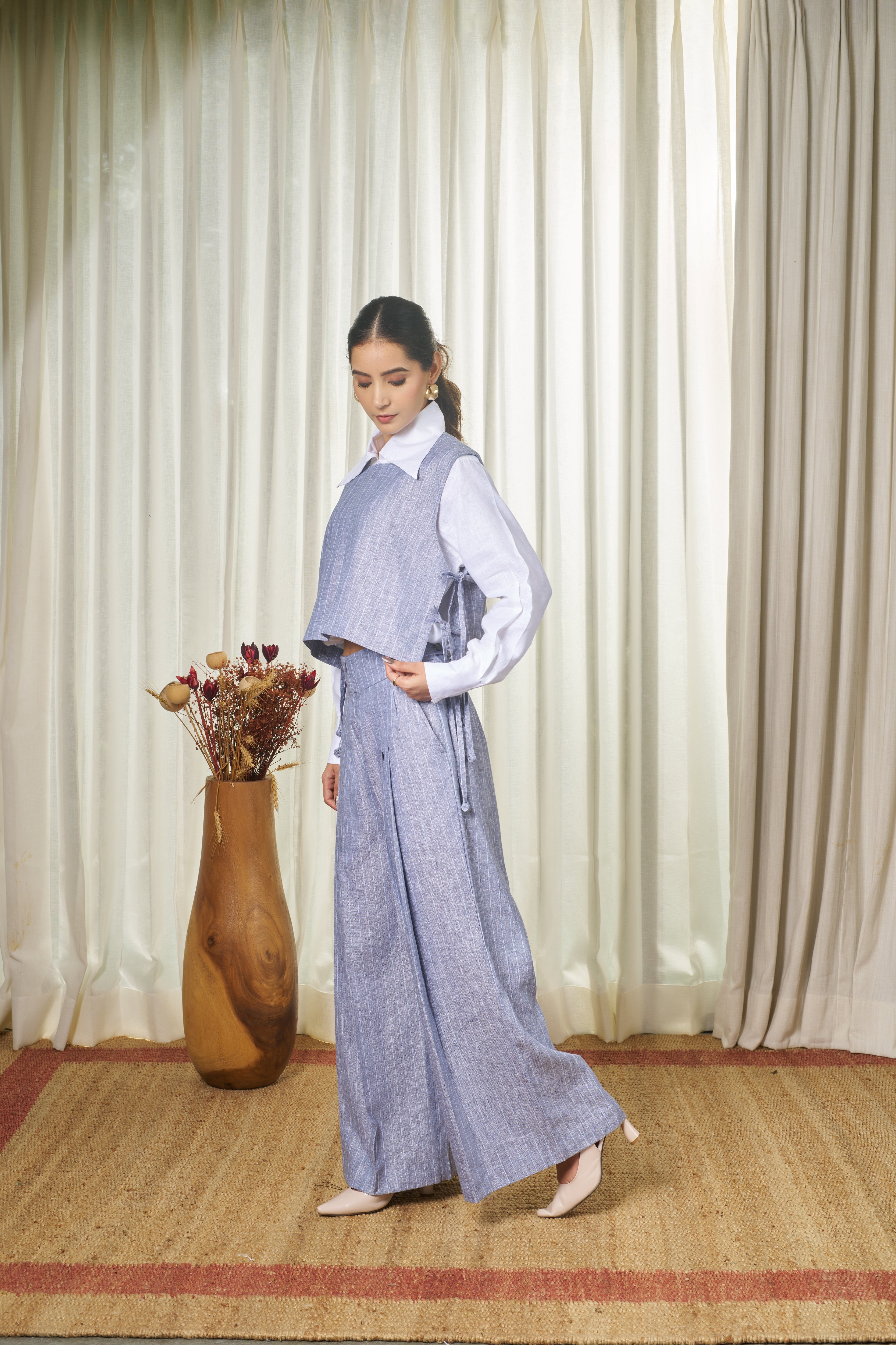 Woman wearing a blue striped outfit with a white shirt.  handmade linen clothing India, minimalist clothing brands India