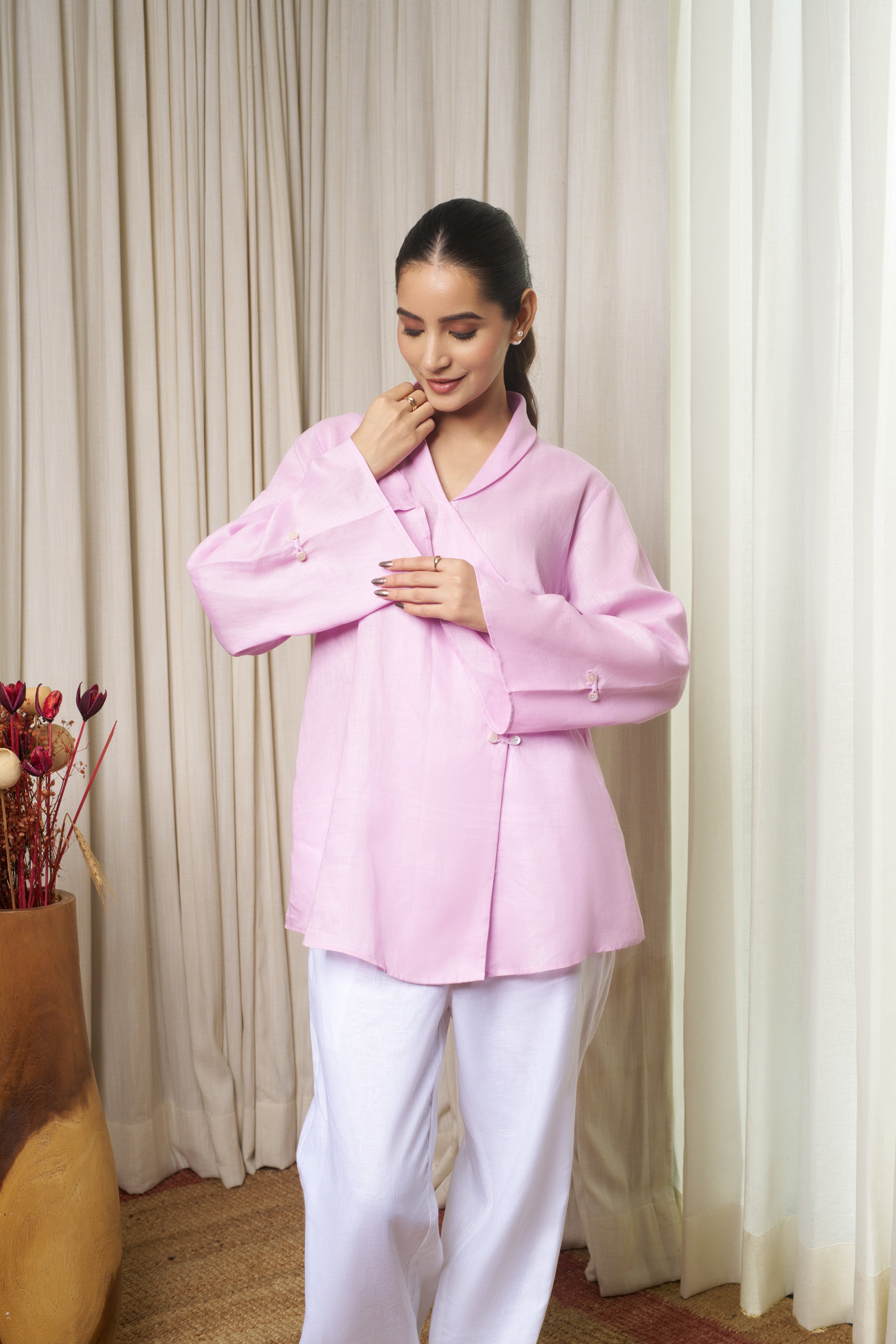 Woman wearing a pink shirt with white pants.Linen clothing mumbai,
sustainable women’s wear India
