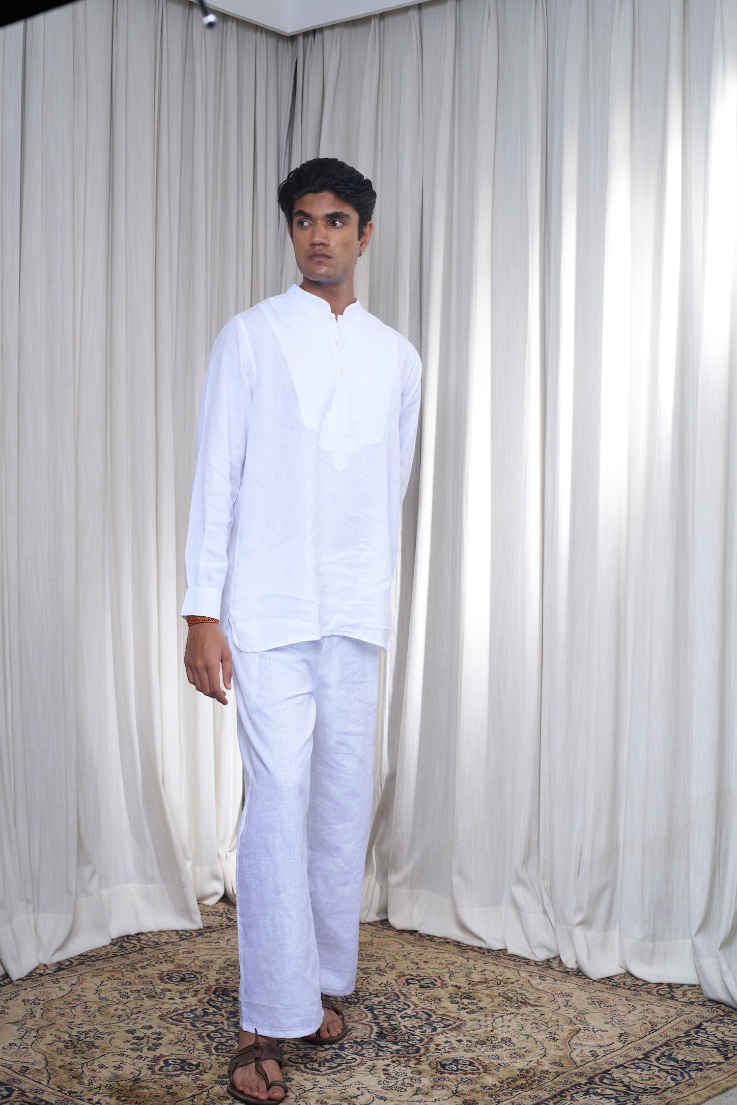Man wearing a white traditional outfit linen pants for men India, sustainable basics for men
