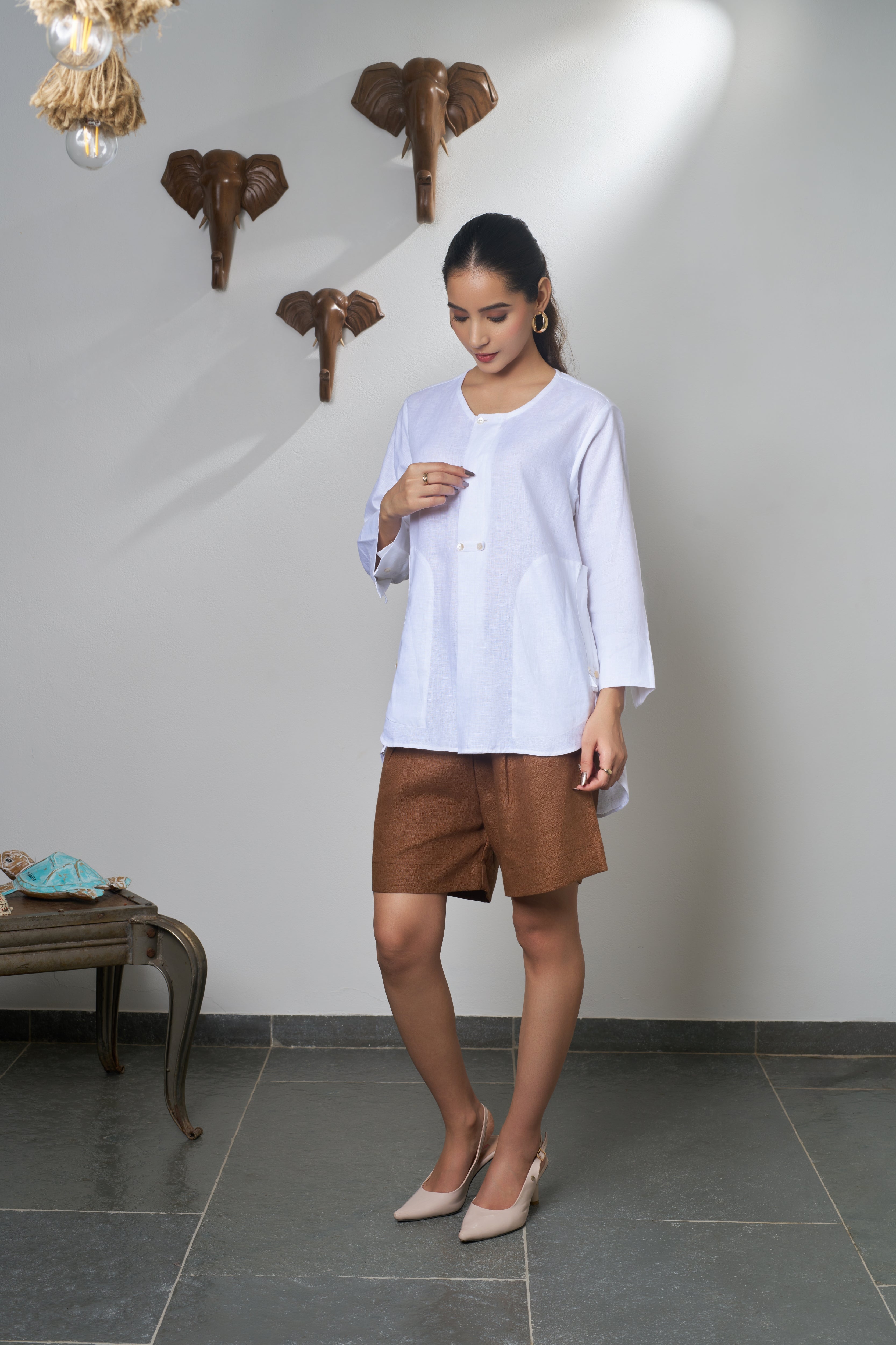 Woman wearing a white shirt and brown shorts. Linen clothing mumbai, 
Casual linen fashion