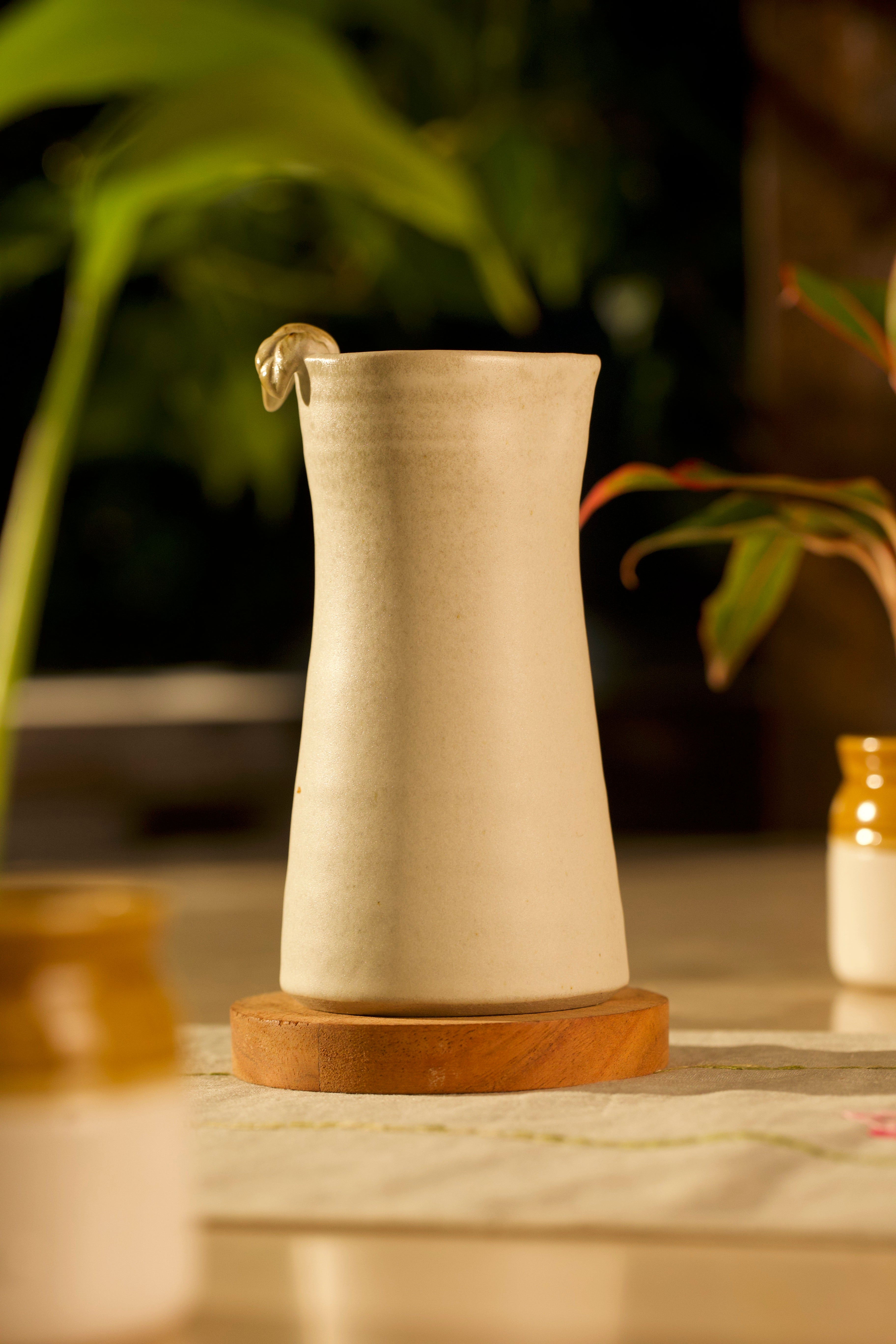 Beige ceramic pitcher on a wooden base, ceramic tableware India, pottery brands in India
