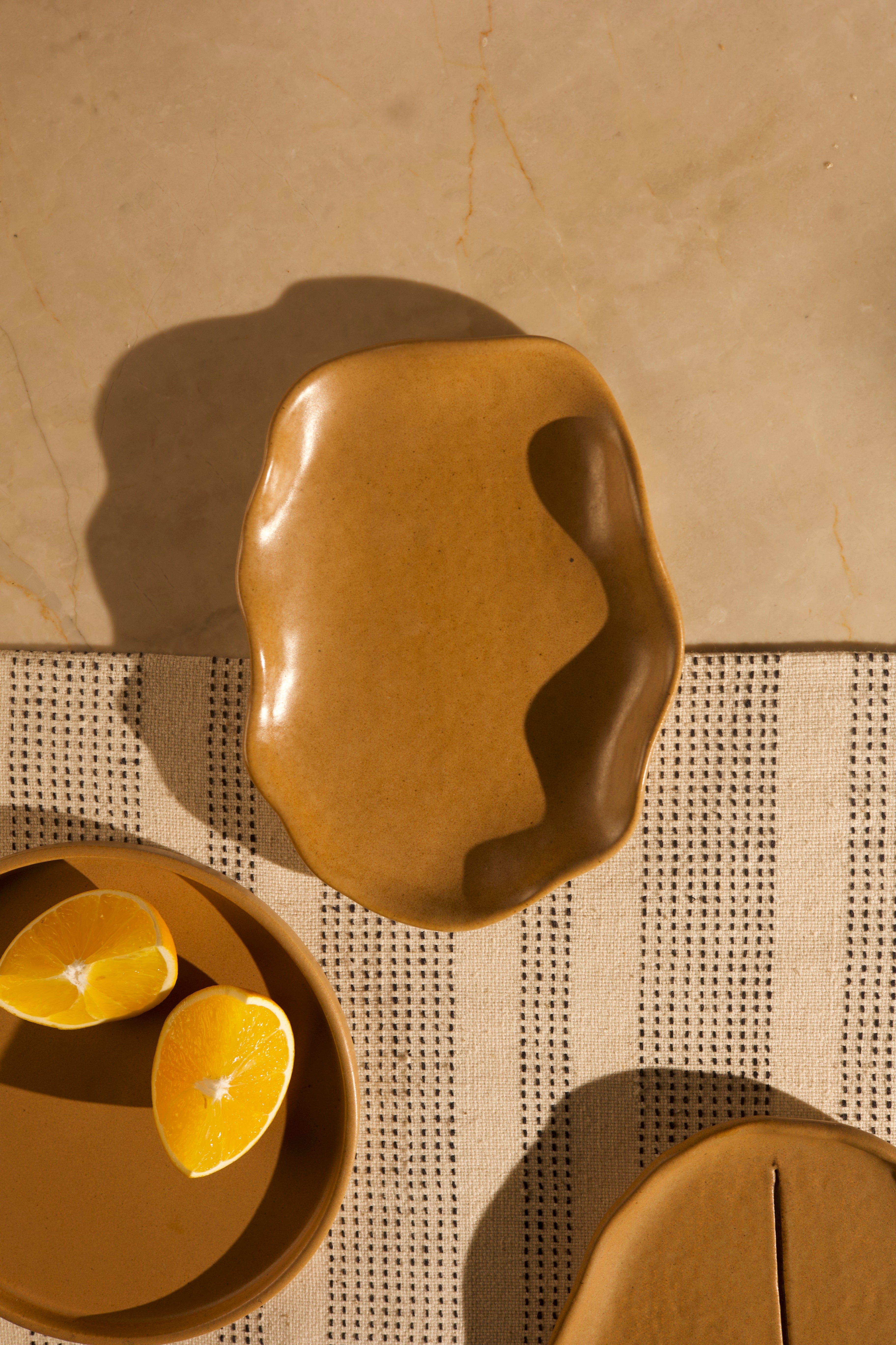 Brown ceramic dish with a textured surface,  handcrafted plates and bowls, dinner plates with natural glaze