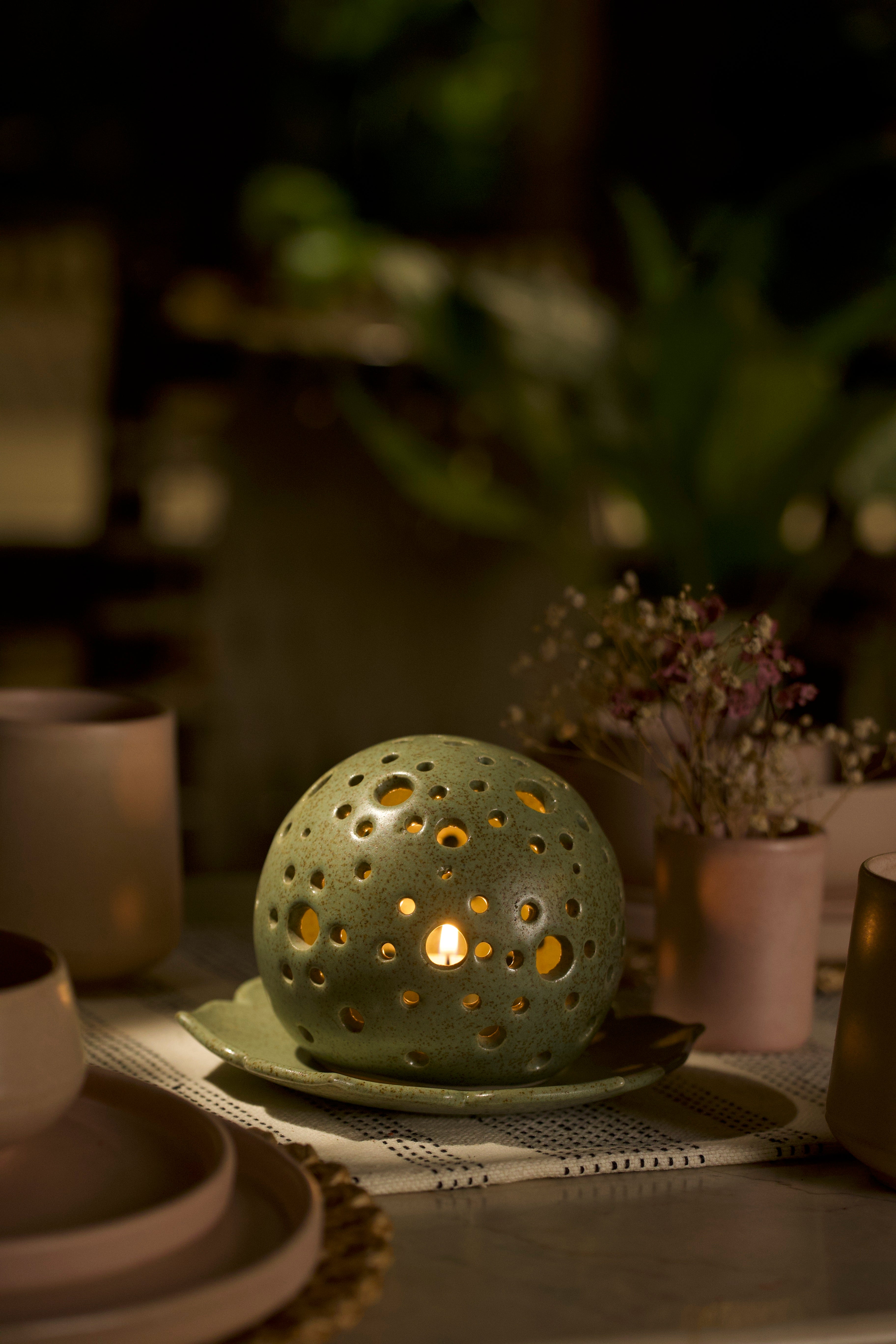 A green decorative ceramic pot with intricate design. minimalist home décor India, handmade ceramics India
