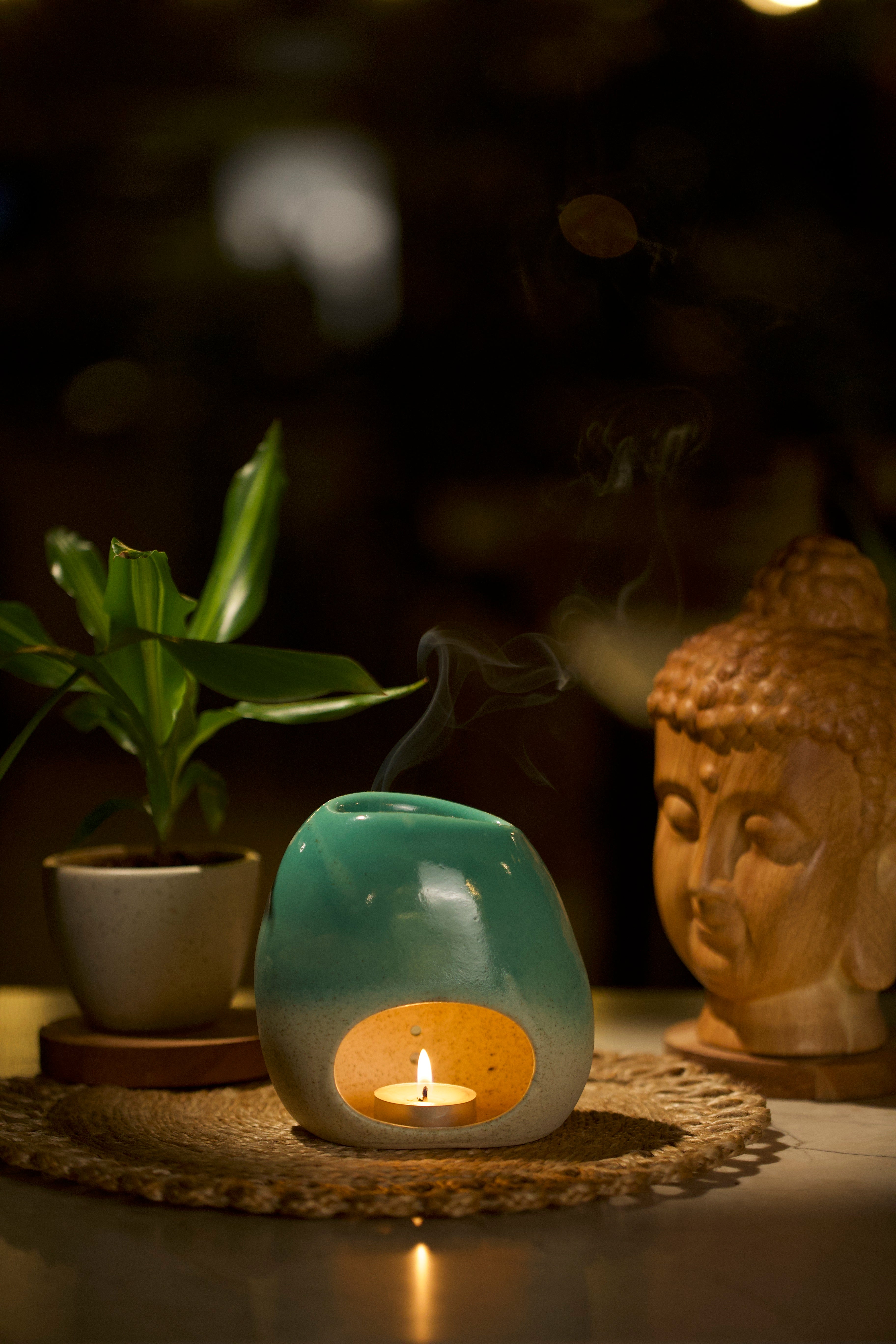Teal Ceramic diffuser with a lit candle inside, Home decor shop online, artisanal home décor India
