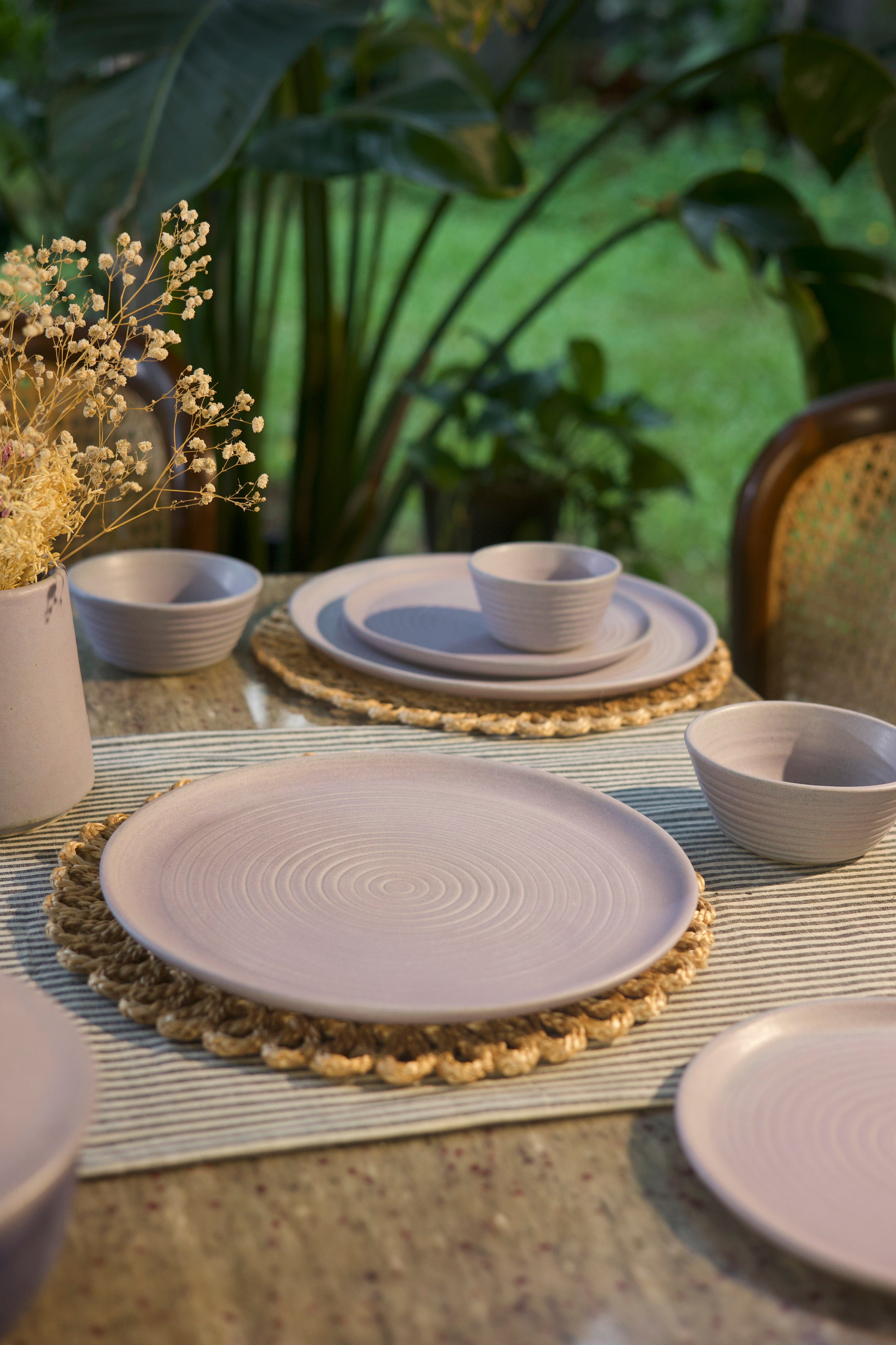 Pink ceramic tableware set on a table with a natural background  handmade dinnerware India, handcrafted plates and bowls